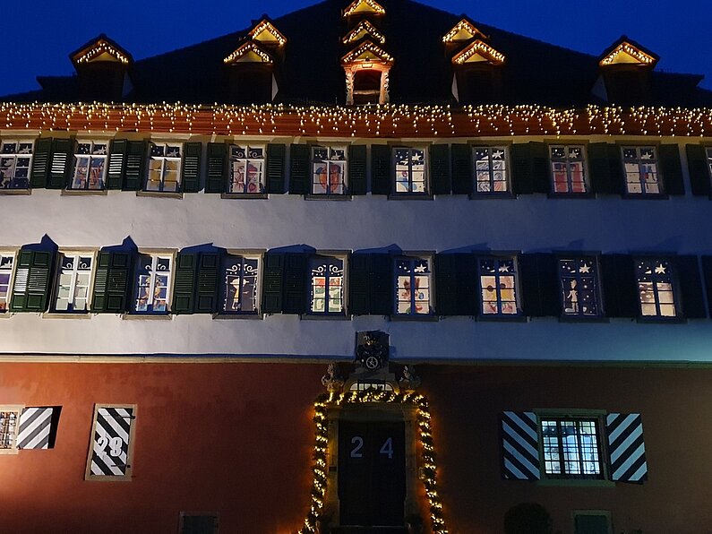 Das beleuchtete rote Schloss in Jagsthausen mit dem Adventskalender bei Nacht 