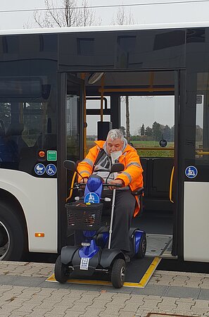 E-Scooter fährt über RAmpe aus dem Bus
